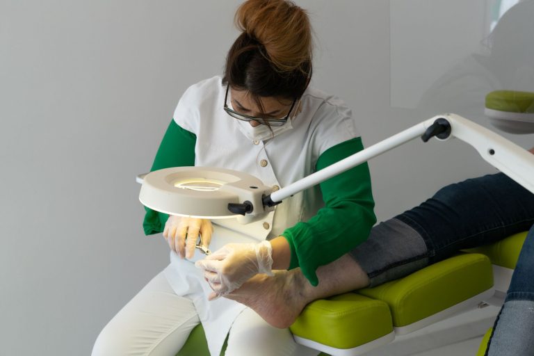 Medizinische Nagelbehandlung am Fuß mit Behandlungslampe